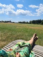 Eine Frau genießt auf einer Liege den Panoramablick am Rand von Wasserdobl bei Aspach