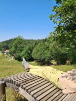 Ein Mann entspannt bei Sonnenschein auf der Panoramaliege bei Wasserdobl Aspach