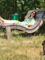 Eine Frau entspannt sich auf der Panoramaliege bei Wasserdobl und beobachtet eine Katze