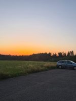Großer Parkplatz am Ortsrand von Wasserdobl im Sonnenuntergang.