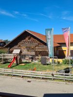Blick vom Balkon auf den Gasthof Höhwirt mit Spielplatz und Biergarten bei sonnigem Wetter.
