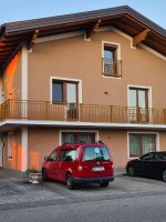 Außenansicht der Ferienwohnung bei Abendlicht mit privaten Parkplätzen direkt vor dem Gebäude.