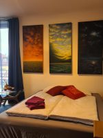 Gemütliche Schlafcouch mit roten Kissen und Decken in einem hellen Zimmer