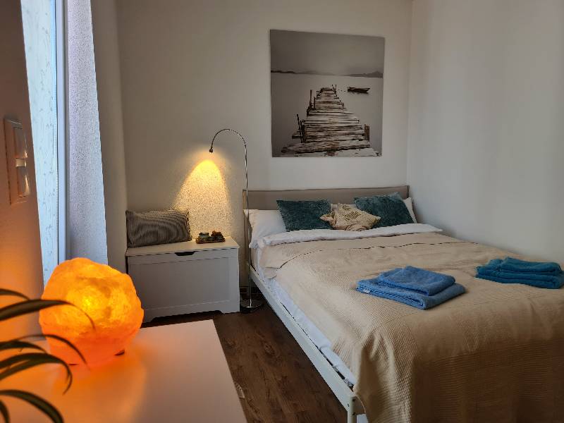 Gemütliches zweites Schlafzimmer der Ferienwohnung am Kobernaußerwald im Innviertel mit warmem Licht einer Salzlampe.